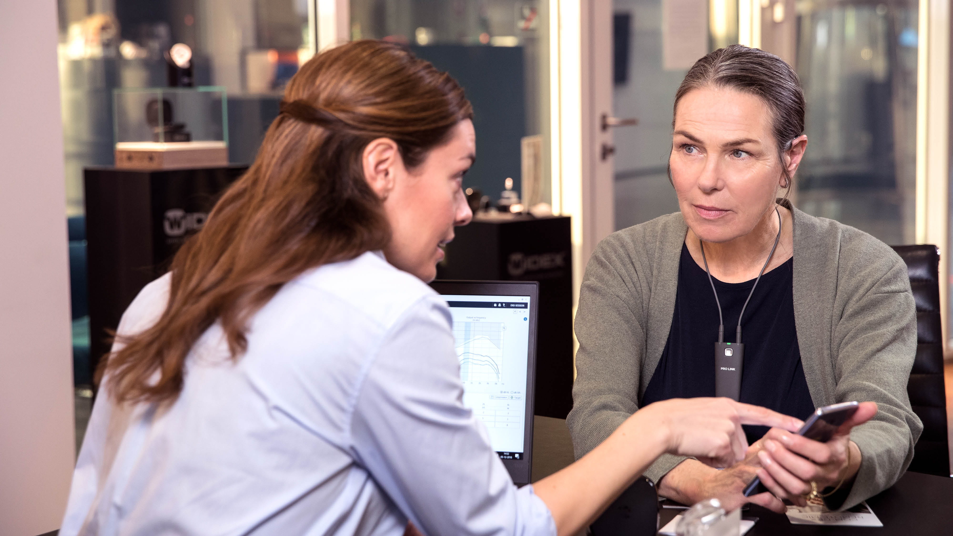 Hörgeräte-Akustikerin und Hörgeräte-Trägerin im Beratungsgespräch