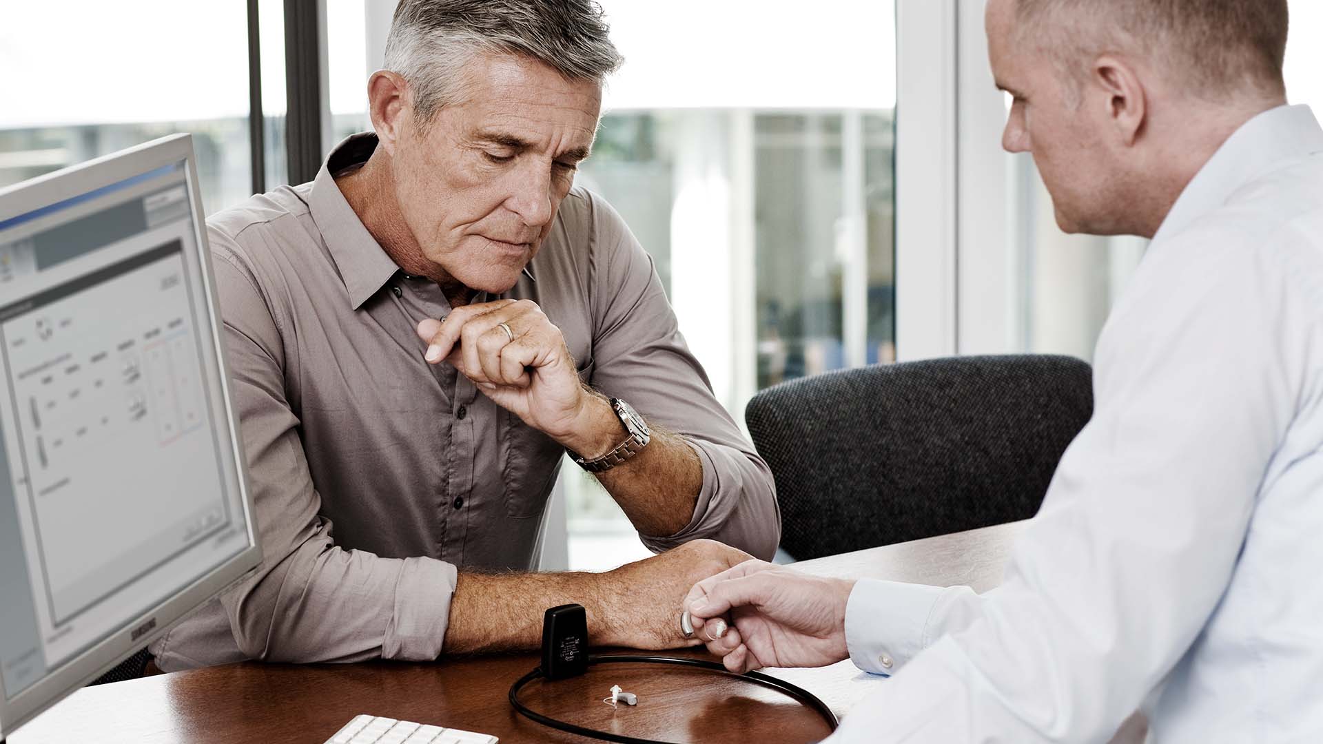 Hearing care professional and patient talking about hearing aids