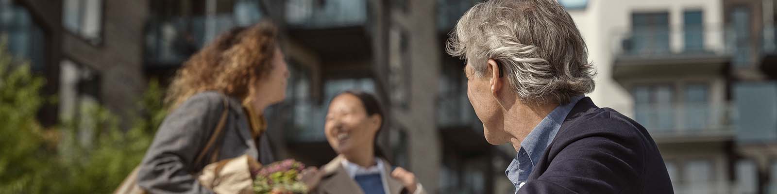 Man sitting on steps and listening to talking women