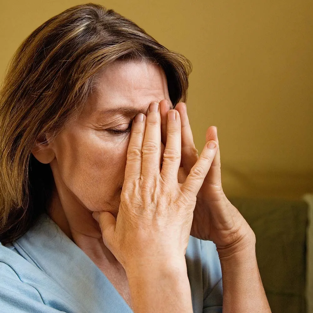 Stressed woman, covering face with hands